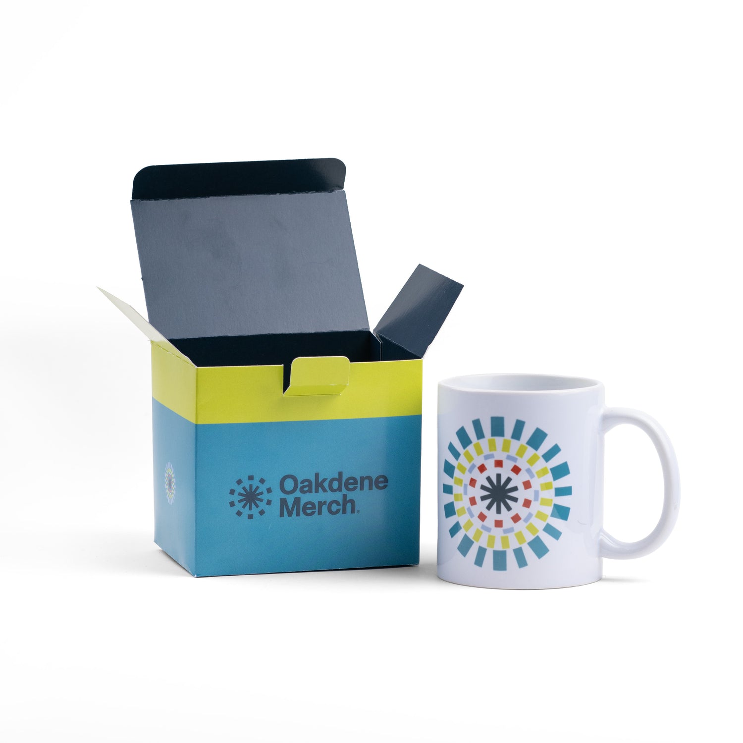A ceramic mug next to an open presentation box labeled Oakdene Merch.