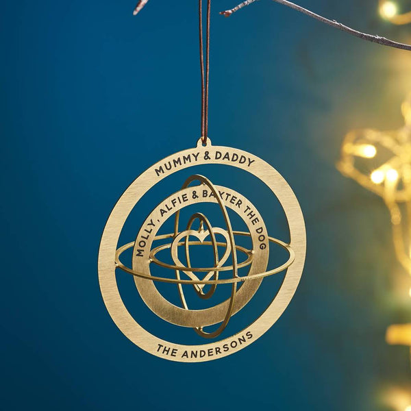 Gold circular ornament with engraved text hanging against a blue background
